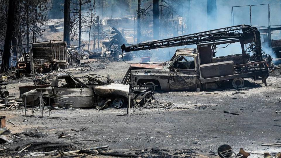 Burnt vehicles on a property near Darrah and Triangle roads smolder after the Oak Fire tore through the area east of Mariposa on Saturday, July 23, 2022.