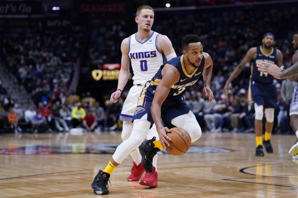 New Orleans Pelicans guard CJ McCollum (3) drives to the basket past Sacramento Kings guard Donte DiVincenzo (0) in the second half of an NBA basketball game in New Orleans, Wednesday, March 2, 2022. The Pelicans won 125-95. (AP Photo/Gerald Herbert)
