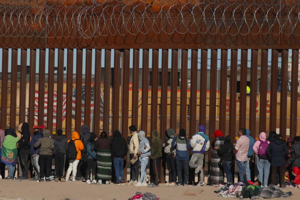 Migrants queue at the border wall to be received by Border Patrol agents after crossing the Rio Bravo river (or Rio Grande river, as it is called in the US) from Ciudad Juarez, Chihuahua state, Mexico, to El Paso, Texas, US on Dec. 21, 2022. - Title 42, a President Donald Trump pandemic-era law that authorizes United States border officials to expel migrants, is slated to end on May 11.