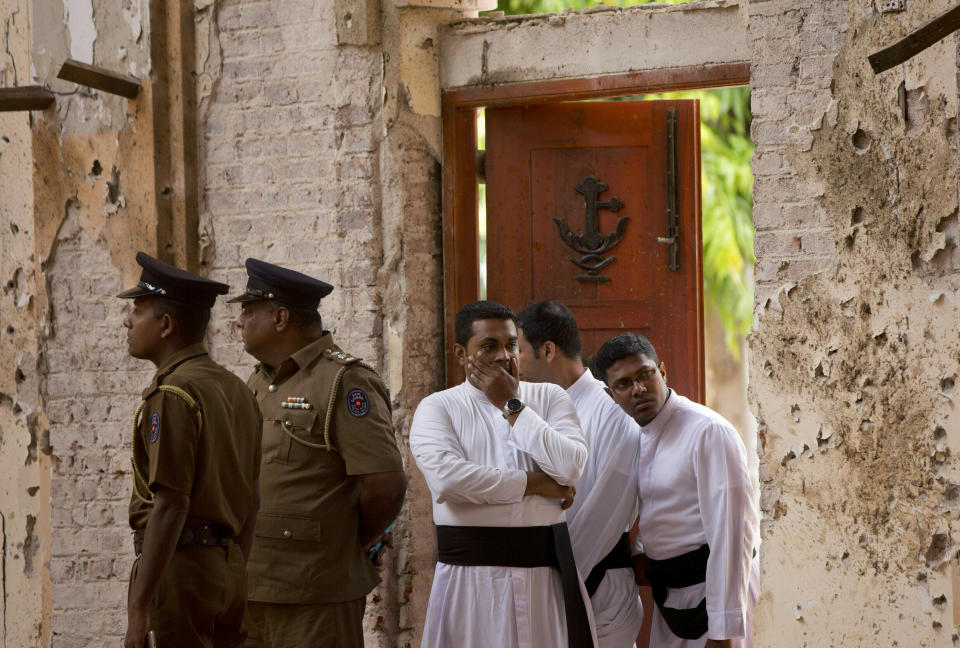 FILE - In this Monday, April 22, 2019 file photo, clergymen visit the scene of a suicide bombing at St. Sebastian's Church in Negombo, Sri Lanka. Roughly 250 people died in six coordinated suicide bombings that ripped through Sri Lanka on Easter Sunday. (AP Photo/Gemunu Amarasinghe, File)