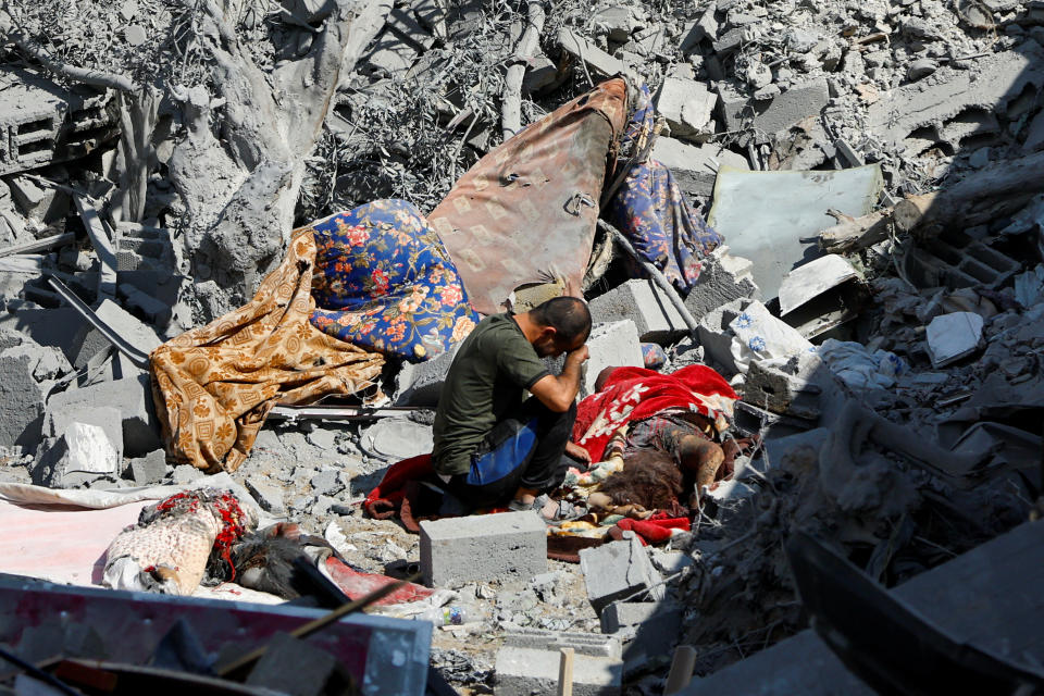 A man reacts next to a body at the site of Israeli strikes on houses in Rafah.
