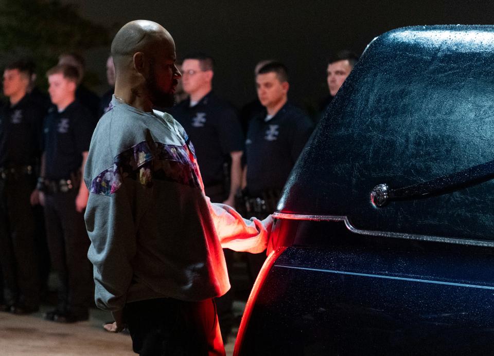 Joshua Massop, brother of fallen Vanderburgh County Sheriff's Deputy Asson Anthony Hacker, says a final goodbye during a service outside Christian Fellowship Church Thursday evening, March 9, 2023.