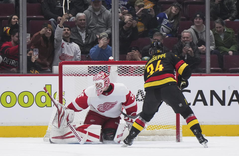 Vancouver Canucks' Phillip Di Giuseppe (34) puts a shot over the crossbar behind the net on a penalty shot against Detroit Red Wings goalie Ville Husso (35) during the third period of an NHL hockey game in Vancouver, British Columbia, Monday, Feb. 13, 2023. (Darryl Dyck/The Canadian Press via AP)