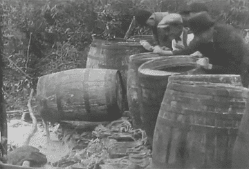 Men dump out barrels of alcohol into mud