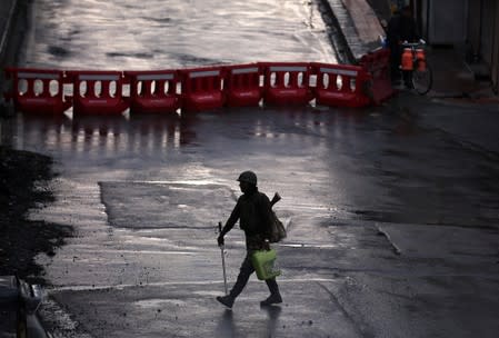 An Indian security force personnel patrols a deserted road during restrictions after the government scrapped special status for Kashmir, in Srinagar