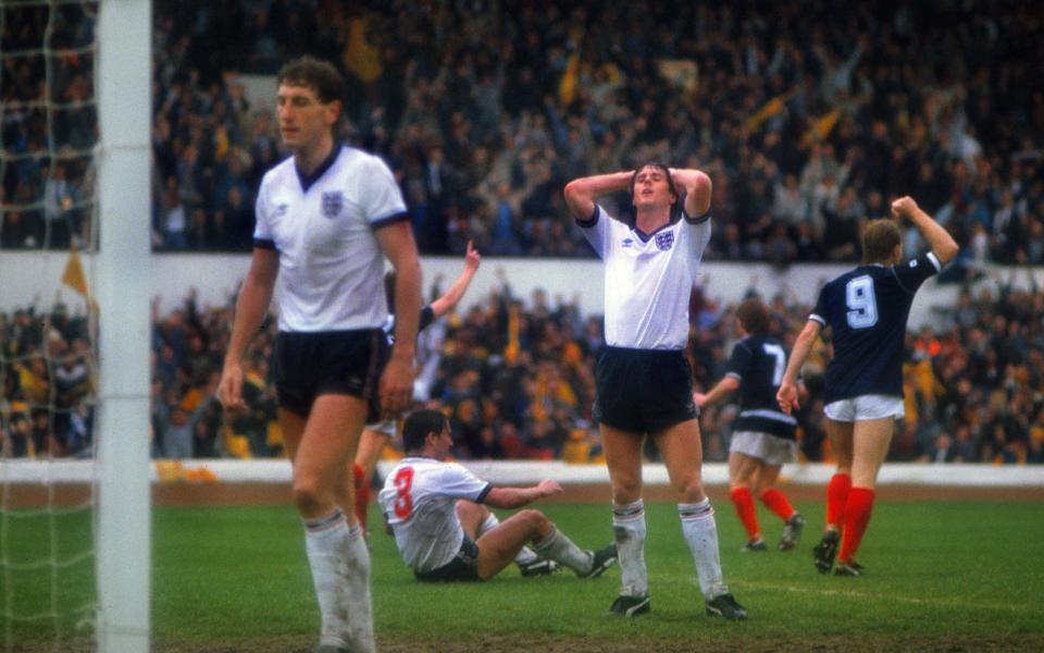 A dejected Terry Fenwick (centre), Terry Butcher (left) and Kenny Sansom (#3 on the ground, who had been beaten for the header) react after Richard Gough's winning goal for Scotland, at Hampden - Colorsport/Shutterstock