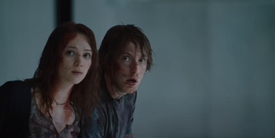 Kristen Connolly and Fran Kranz in a scene from "The Cabin in the Woods," looking frightened with blood on their faces and clothing