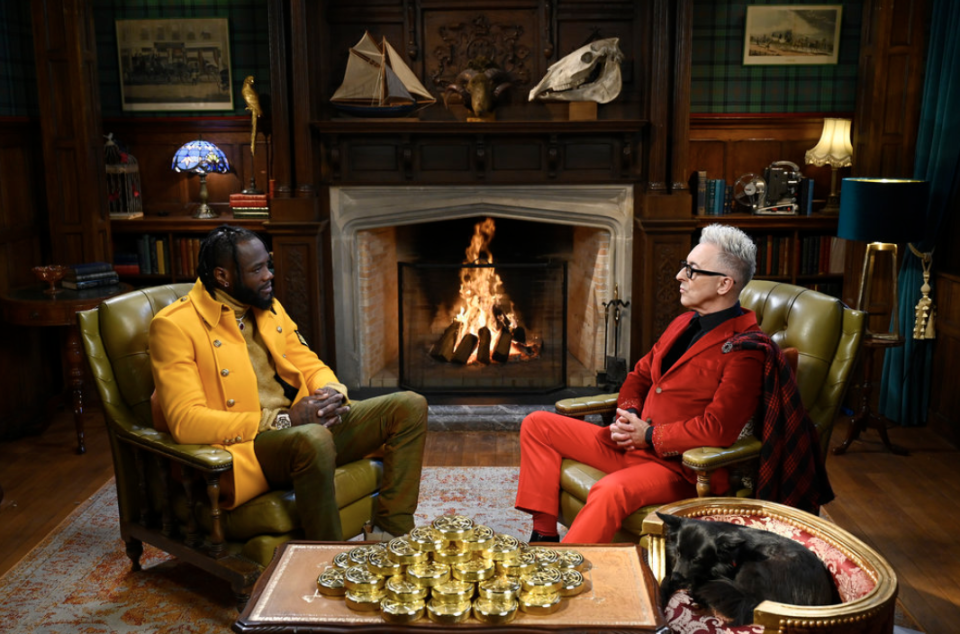 people sitting in chairs in front of a fireplace