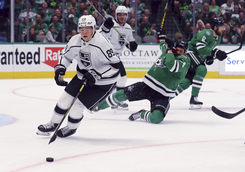 Los Angeles Kings center Rasmus Kupari (89) gets the puck away from Dallas Stars left wing Jamie Benn (14) in the first period of an NHL hockey game Friday, Oct. 22, 2021, in Dallas. (AP Photo/Richard W. Rodriguez)