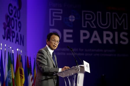 FILE PHOTO: Japanese Finance Minister Taro Aso delivers a speech during a high-level forum on debt at the Finance Ministry in Paris