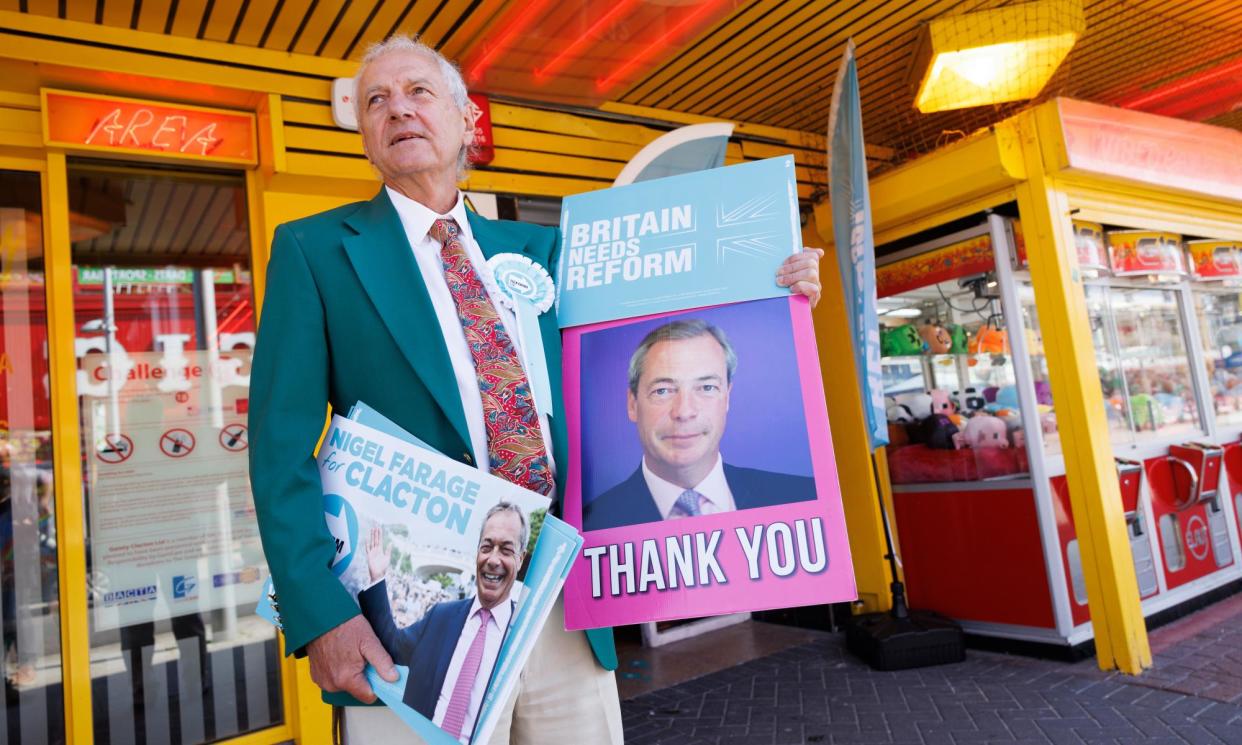 <span>A Reform activist distributes party material outside their offices in Clacton-on-Sea in Essex.</span><span>Photograph: Dan Kitwood/Getty Images</span>