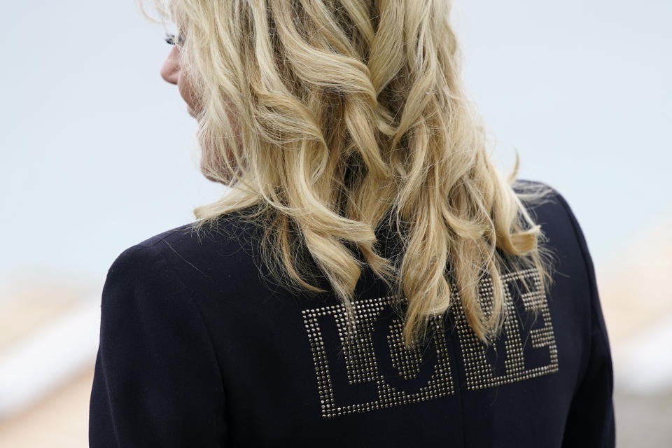 First lady Jill Biden turns around to show the word "love" on the back of her jacket as she speaks with reporters after visiting with Carrie Johnson, wife of British Prime Minister Boris Johnson, ahead of the G-7 summit, Thursday, June 10, 2021, in Carbis Bay, England. (AP Photo/Patrick Semansky)