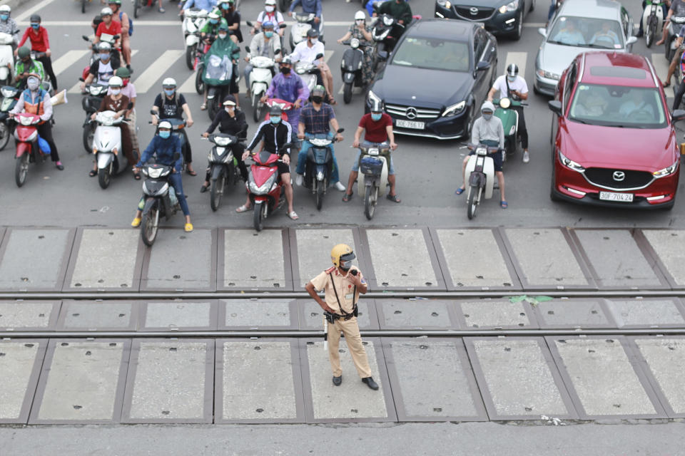 A policeman manages the traffic in Hanoi, Vietnam on Wednesday, Sept. 16, 2020. Vietnam will resume international commercial flights connecting the country to several Asian destinations after a monthslong shutdown to curb the coronavirus outbreak. (AP Photo/Hau Dinh)