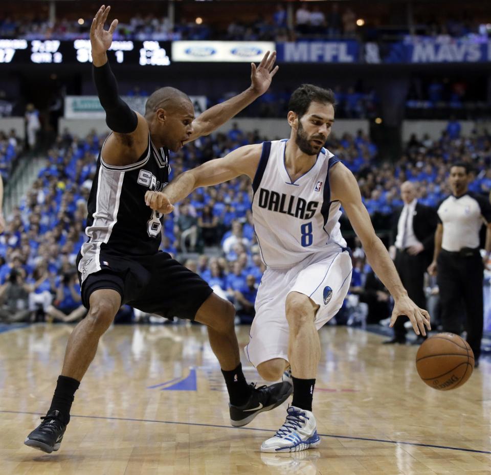 San Antonio Spurs' Patty Mills, left, is knocked back by Dallas Mavericks' Jose Calderon as Calderon loses control of the dribble in the first half of Game 4 of an NBA basketball first-round playoff series, Monday, April 28, 2014, in Dallas. (AP Photo/Tony Gutierrez)