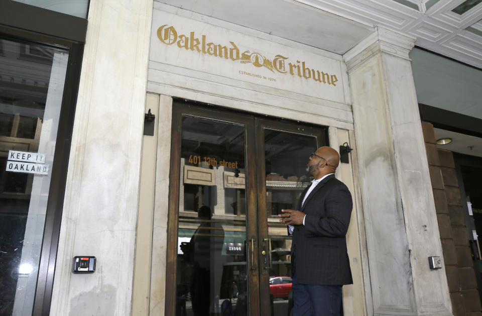 In this July 2, 2019, photo, Martin Reynolds, co-executive director of the Maynard Institute, looks at the gold script above a doorway to the Tribune Tower, the former home of the Oakland Tribune newspaper during an interview in Oakland , Calif. "There was a time when newspapers were so powerful and so meaningful and so influential to the community," said Reynolds, who started as an intern at the Oakland Tribune and became editor in 2008. "To have lost that is a shame." (AP Photo/Eric Risberg)