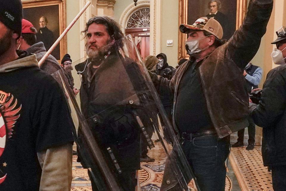 Rioters, including Dominic Pezzola, center with police shield, are confronted by U.S. Capitol Police officers outside the Senate Chamber inside the Capitol, Wednesday, Jan. 6, 2021, in Washington.
