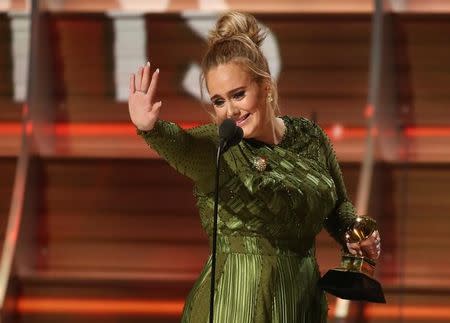 Adele waves to singer Beyonce who is in the audience as she and co-song writer Greg Kurstin (not pictured) accept the Grammy for Song of the Year for "Hello" at the 59th Annual Grammy Awards in Los Angeles, California, U.S. , February 12, 2017. REUTERS/Lucy Nicholson