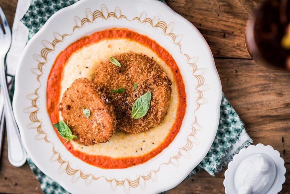 Famous fried green tomatoes at Tupelo Honey Southern Kitchen: panko-crusted fried green tomatoes, basil-roasted red pepper sauce, served over stone-ground goat cheese grits.