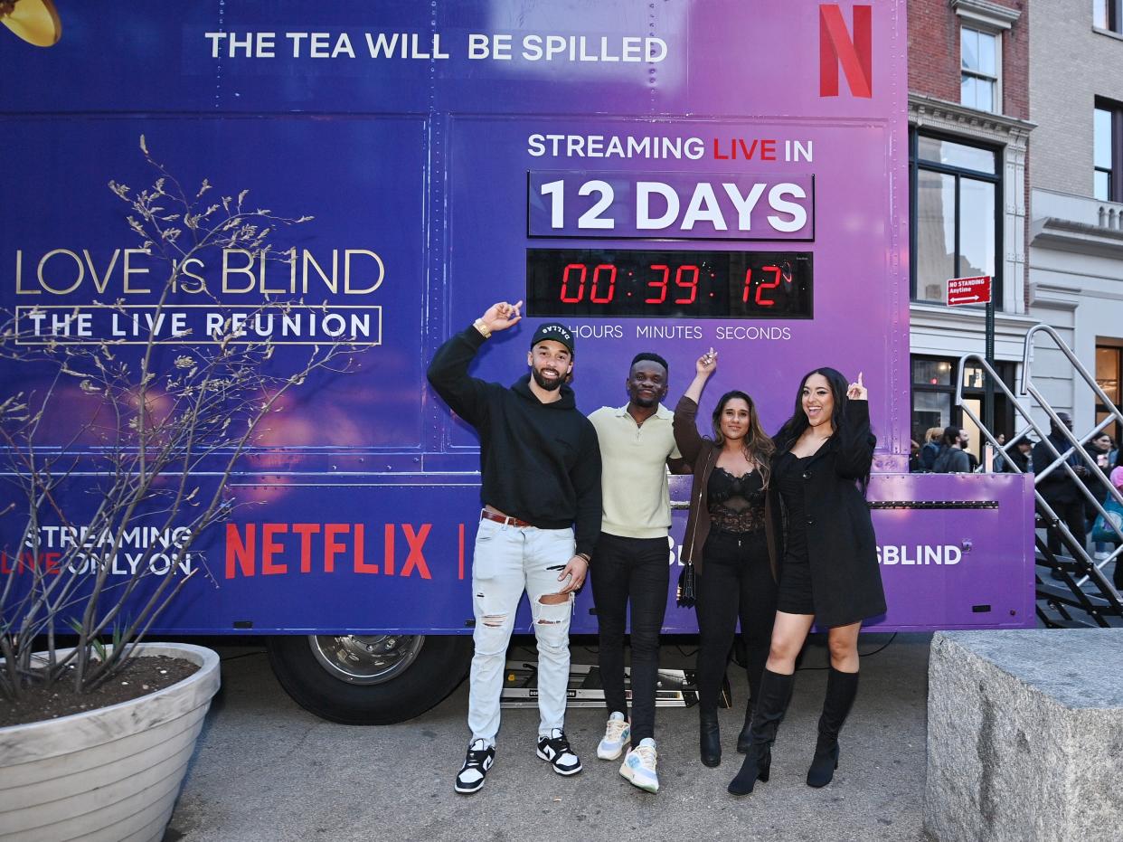 The cast for "Love is Blind" pose for a picture while standing stand in front of countdown clock for the release of the first live reunion on Netflix.