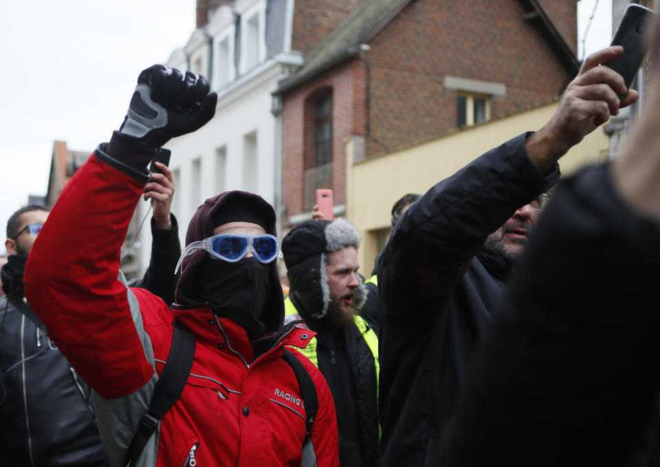 Demonstrators protest before French President Emmanuel Macron's visit in Grand Bourgtheroulde, Normandy, Tuesday, Jan.15, 2019. Macron is formally launching a "grand debate" to try to appease the yellow vest movement following weeks of anti-government protests. (AP Photo/Francois Mori)