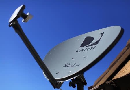 A DirecTV satellite dish is seen on a residential home in Encinitas, California November 5, 2014. REUTERS/Mike Blake