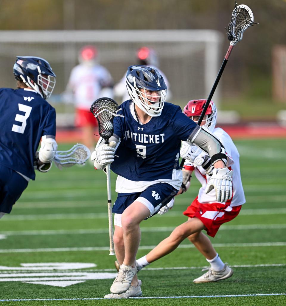 Paddy Carroll of Nantucket moves past Jack Bunnell of Barnstable boys lacrosse.