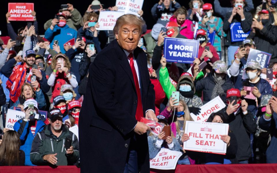 US President Donald Trump throws masks as he arrives to hold a Make America Great Again rally as he campaigns at John Murtha Johnstown-Cambria County Airport in Johnstown, Pennsylvania, October 13, 2020. (Photo by SAUL LOEB / AFP) (Photo by SAUL LOEB/AFP via Getty Images) ORG XMIT: 0 ORIG FILE ID: AFP_8T26EC.jpg