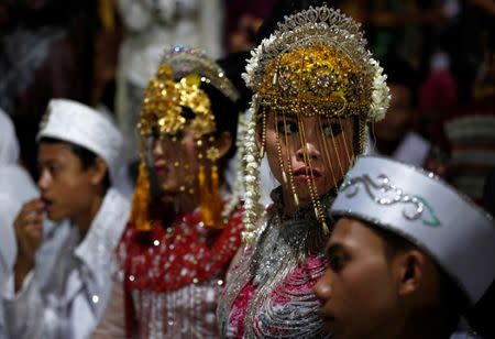 Couples take part in a mass wedding organised by the city government as part of New Year's Eve celebrations in Jakarta, Indonesia, December 31, 2017. REUTERS/Darren Whiteside