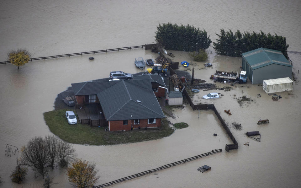 A farm house and buildings are surrounded by flood waters in Canterbury, New Zealand, Monday, May 31, 2021. Several hundred people in New Zealand were evacuated from their homes while others recounted dramatic helicopter rescues as heavy rain caused widespread flooding in the Canterbury region. (George Heard/NZ Herald via AP)