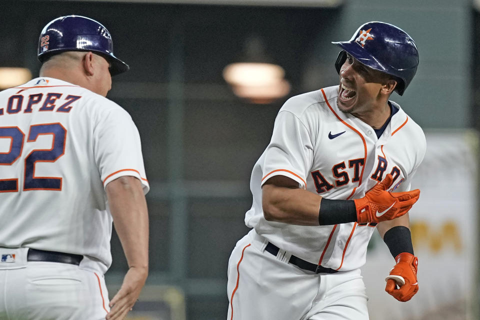 Houston Astros' Michael Brantley, right, celebrates with third base coach Omar Lopez (22) after hitting a three-run home run against the Chicago White Sox during the first inning of a baseball game Thursday, June 17, 2021, in Houston. (AP Photo/David J. Phillip)