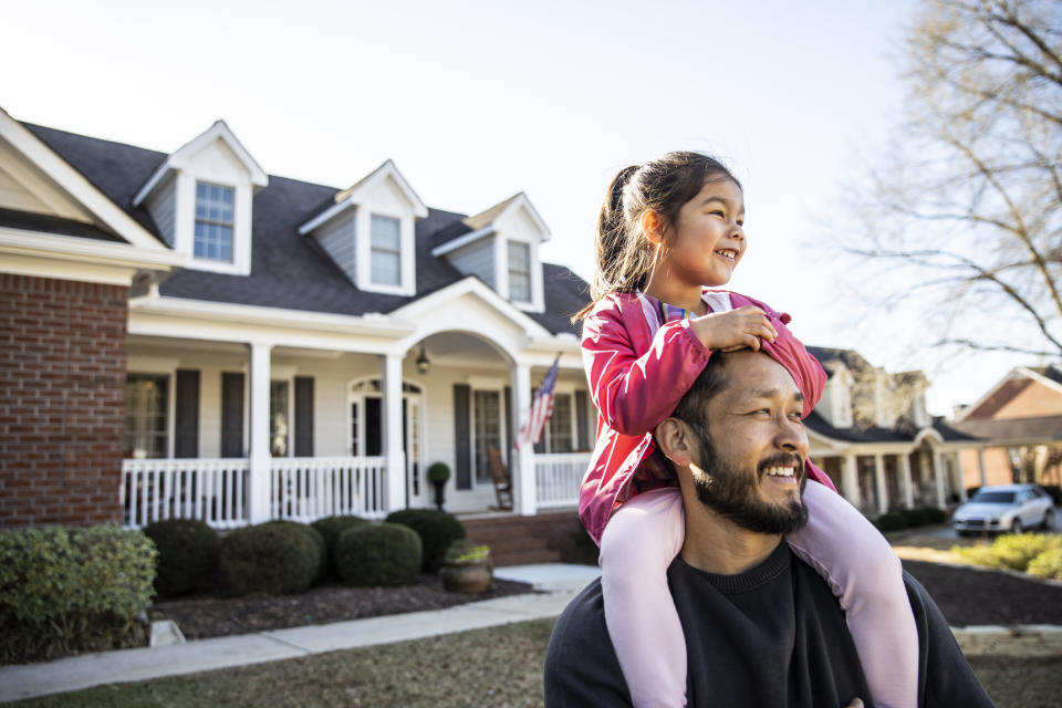 A dad and daughter are enjoying the day in their suburban neighborhood