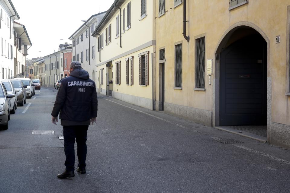 A NAS (Carabinieri for the Protection of Public Health and the Environment) Carabinieri officer patrols the town of Codogno, near Lodi, Northern Italy, Saturday, Feb. 22, 2020. A dozen northern Italian towns were on effective lockdown Saturday after the new virus linked to China claimed two fatalities in Italy and sickened an increasing number of people who had no direct links to the origin of the virus. The secondary contagions prompted local authorities in towns in Lombardy and Veneto to order schools, businesses and restaurants closed, and to cancel sporting events and Masses. (AP Photo/Luca Bruno)