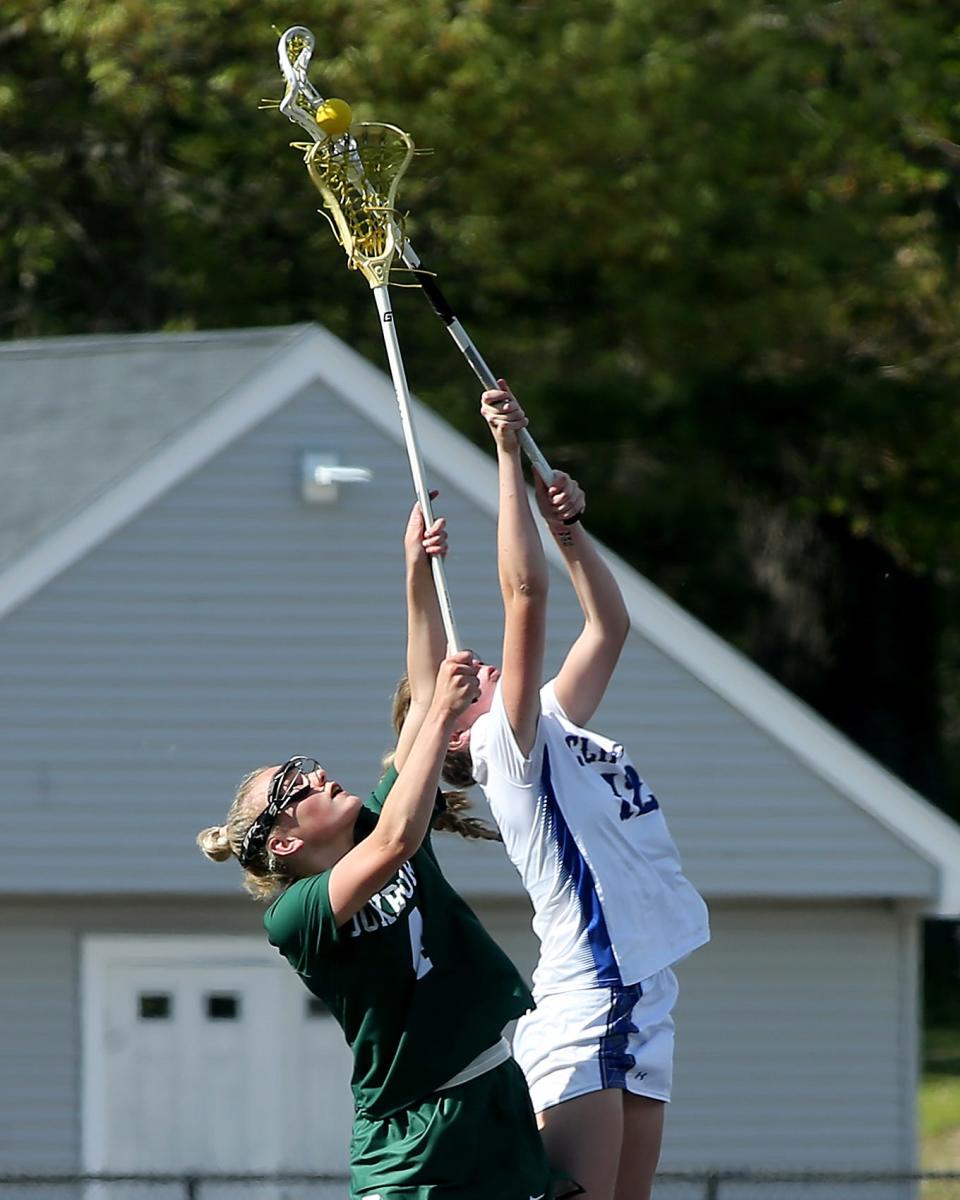 Duxbury's Ellie Wall leaps and wins the face-off draw from Norwell's Charlise Cox during their game at the Norwell Clipper Community Complex on Friday, May 12, 2023.