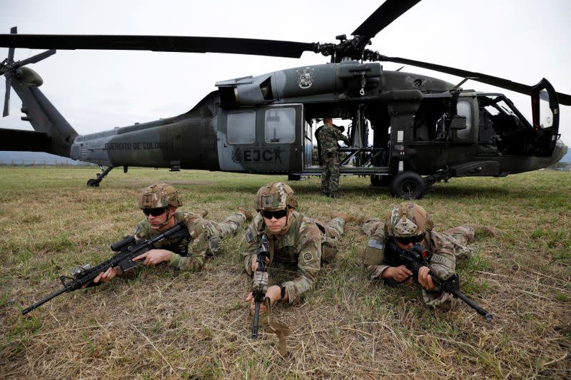 Soldados estadounidenses y colombianos aseguran la zona durante el aterrizaje de heicópteros UH-60 Black Hawk durante un ejercicio militar en la base de Tolemaida, Colombia.