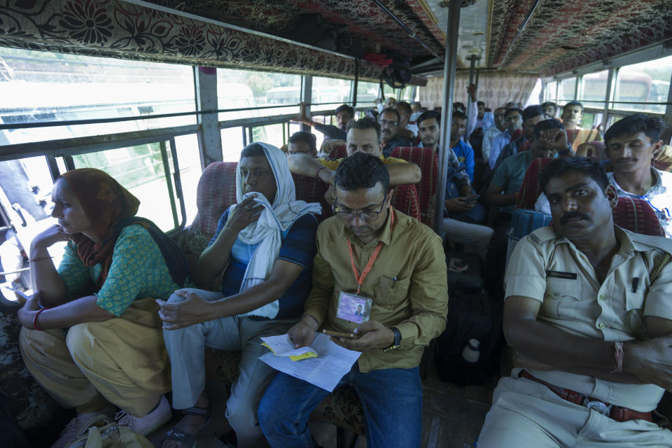 Officials and security personnel board a vehicle as they head to their assigned polling stations on the eve of the second phase of national elections at Barmer, Rajasthan, India, Thursday, April 25, 2024. (AP Photo/ Deepak Sharma)