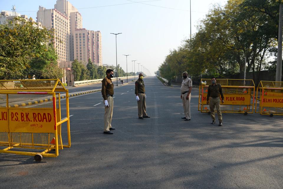 Police personnel stand guard on a deserted road during a one-day Janata (civil) curfew imposed amid concerns over the spread of the COVID-19 novel coronavirus, in New Delhi on March 22, 2020. (Photo by Sajjad HUSSAIN / AFP) (Photo by SAJJAD HUSSAIN/AFP via Getty Images)