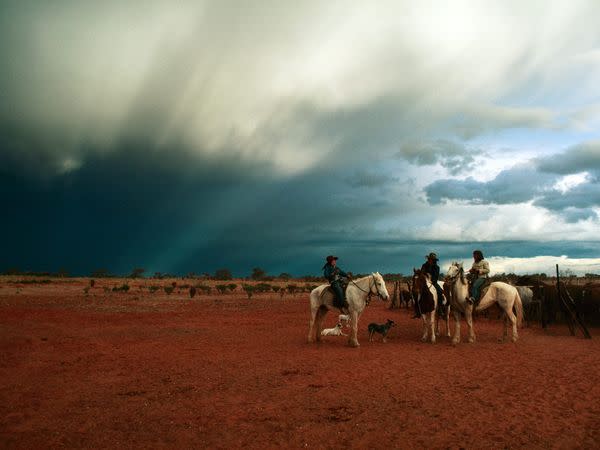 The sky stretches far and wide above cowgirls—or jillaroos—on a cattle ranch in Queensland. Ranching is serious business in Australia.