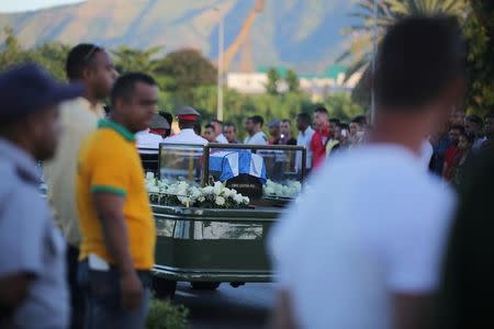 People watch the cortege carrying the ashes of Cuba's former President Fidel Castro drive toward Santa Ifigenia cemetery in Santiago de Cuba, Cuba, December 4, 2016. REUTERS/Carlos Barria