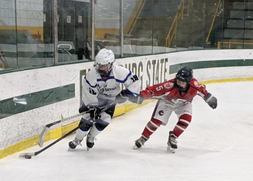 Leominster's Rachel Simkewicz (18) keeps the puck out of the reach of Central Catholic defender Maddie Burke while skating behind the Raiders' net during Monday's game at the Wallace Civic Center in Fitchburg.