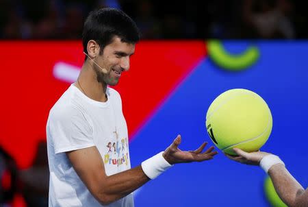 Serbia's Novak Djokovic is given a large tennis ball during a promotional event ahead of the Australian Open tennis tournament in Melbourne, Australia, January 14, 2017. REUTERS/Edgar Su