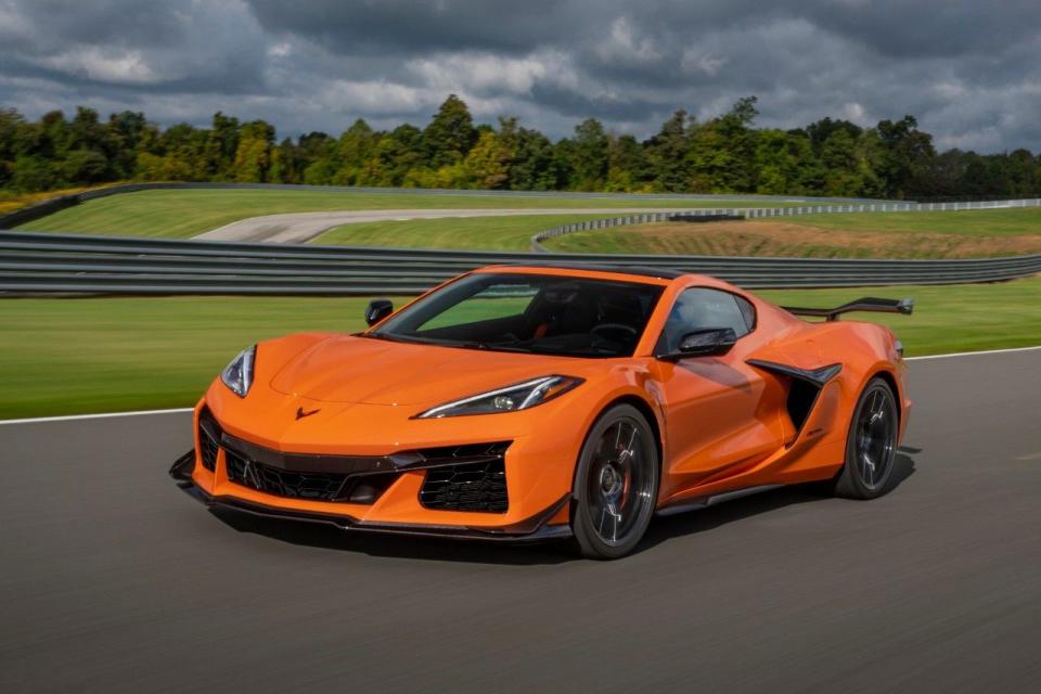 front 34 view of a 2024 chevrolet corvette z06 in amplify orange tintcoat driving on a track