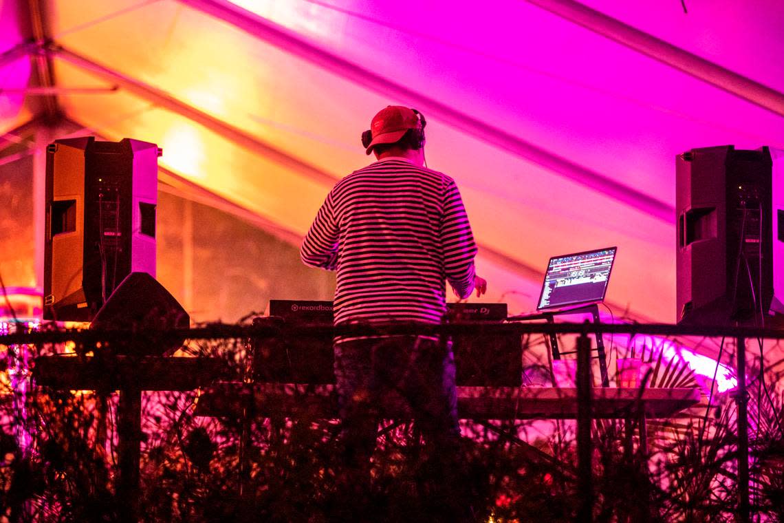 A disc jockey plays dance music in an outdoor area at Alchemy in the Glenwood South bar and restaurant district in Raleigh Wednesday night, Nov. 25, 2020.