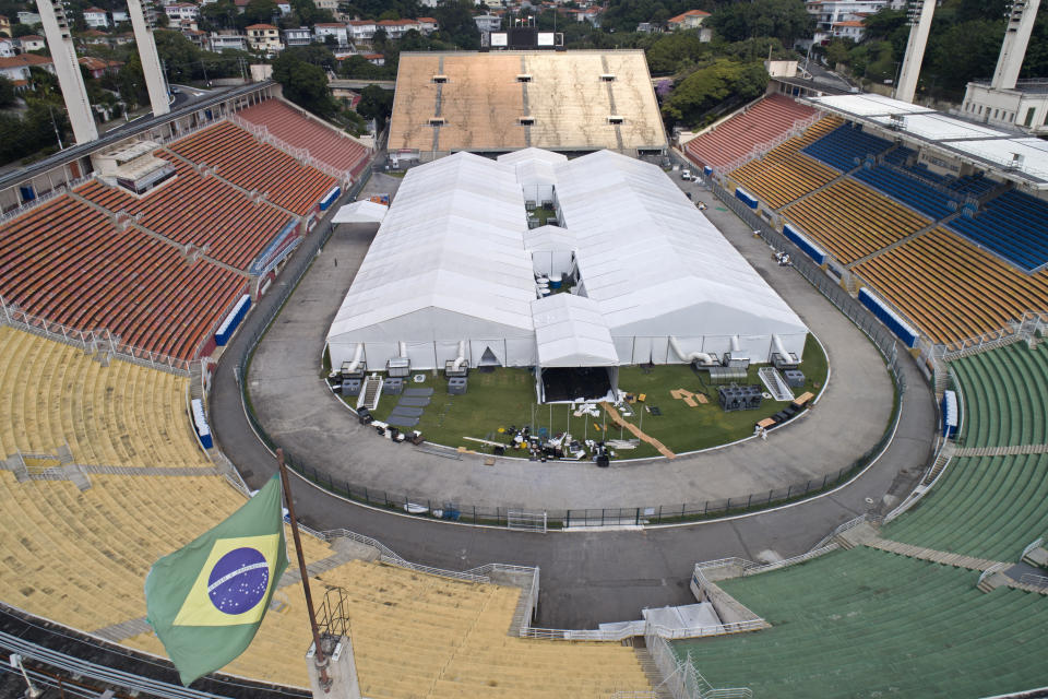 Trabajadores instalan un hospital temporal para tratar pacientes con el nuevo coronavirus en el estadio Pacaembu en Sao Paulo, Brasil, el lunes 30 de marzo de 2020. (AP Foto/Andre Penner)