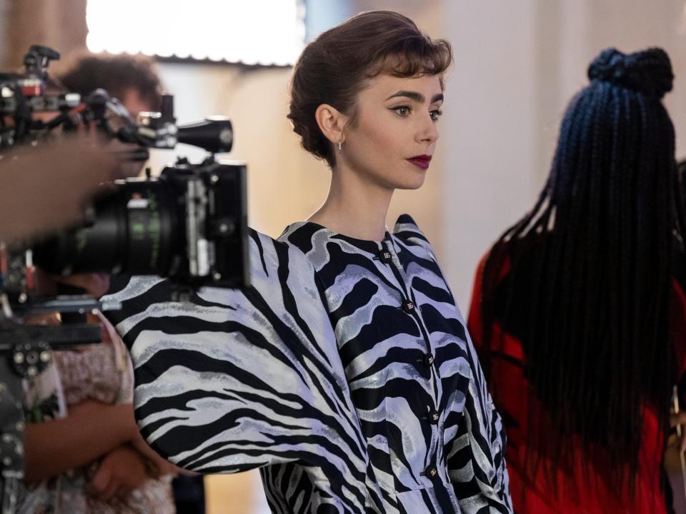 Lily Collins wearing the zebra print jacket shooting "Emily in Paris."