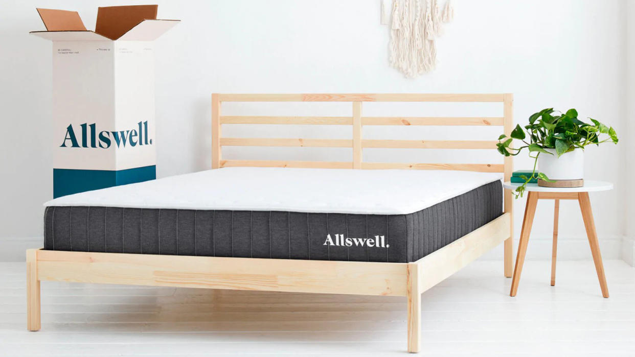  The The Allswell Hybrid Mattress photographed on a light wooden bedframe in a white bedroom. 