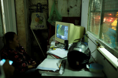 A woman watches closed circuit television system at the entrance of the abandoned Prestes Maia textile factory occupied by a homeless movement in downtown Sao Paulo, Brazil, May 9, 2018. REUTERS/Nacho Doce