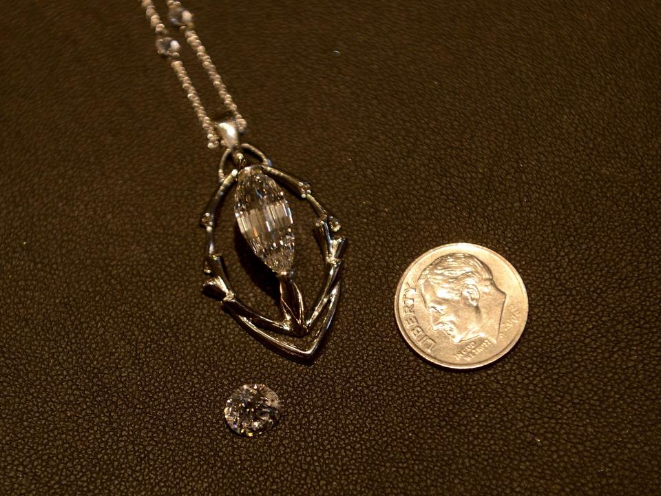 The Esperanza Diamond placed in comparison to a 1.5 carat diamond and a dime.