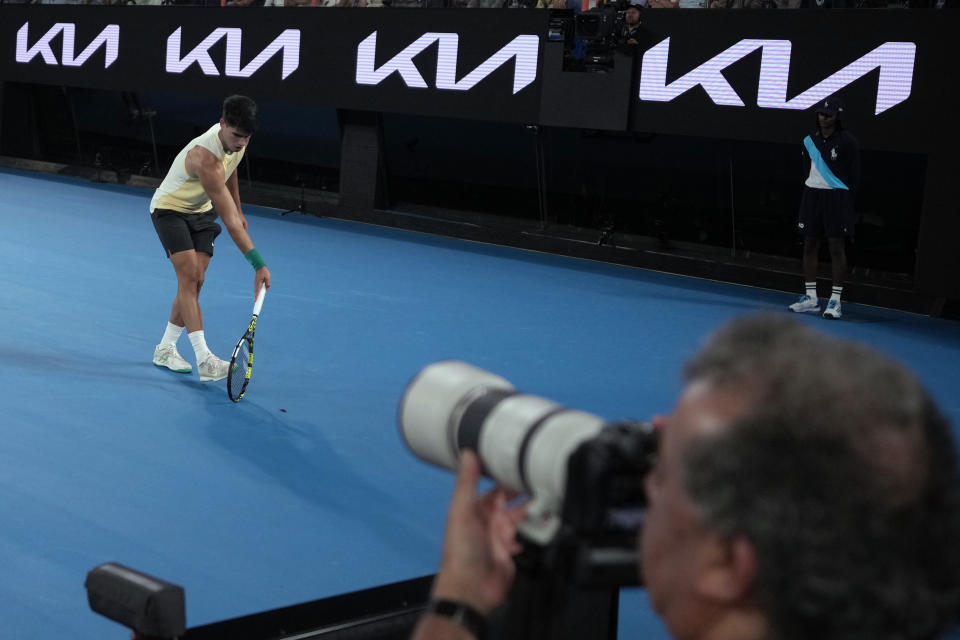 Carlos Alcaraz of Spain stops his first round match against Richard Gasquet of France to move an insect from the court at the Australian Open tennis championships at Melbourne Park, Melbourne, Australia, Tuesday, Jan. 16, 2024. (AP Photo/Andy Wong)