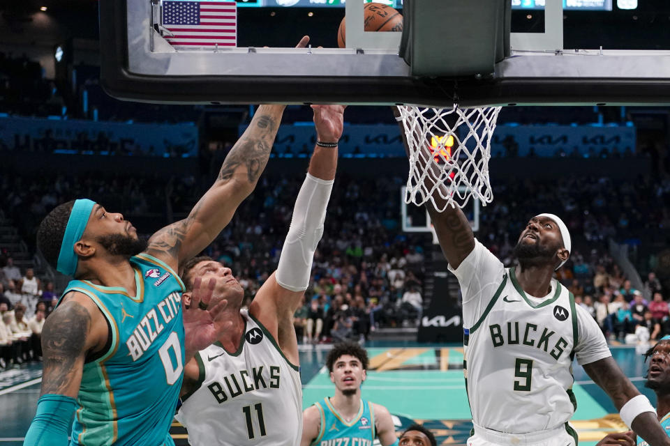 Charlotte Hornets forward Miles Bridges, left, goes up for a rebound against Milwaukee Bucks center Brook Lopez (11) and forward Bobby Portis (9) during the first half of an NBA basketball game on Friday, Nov. 17, 2023, in Charlotte, N.C. (AP Photo/Chris Carlson)