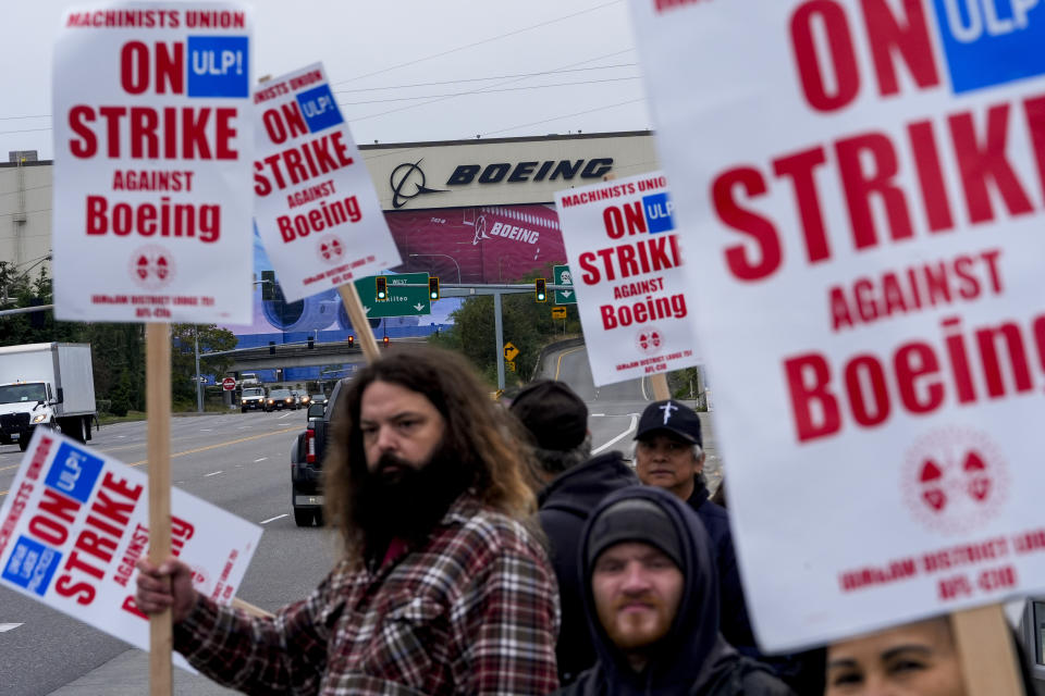 Boeing workers wave picket signs to passing drivers as they strike after union members voted to reject a contract offer Sunday, Sept. 15, 2024, near the company's factory in Everett, Wash. (AP Photo/Lindsey Wasson)